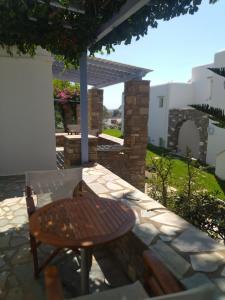 a wooden table and a bench on a patio at Elena Studios & Apartments in Piso Livadi