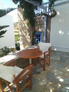 een houten tafel en stoelen op een patio bij Elena Studios & Apartments in Piso Livadi