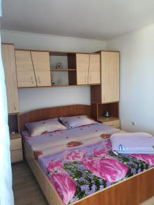 a bedroom with a large bed with pink sheets at Pensiunea Nina in 2 Mai +5 photos