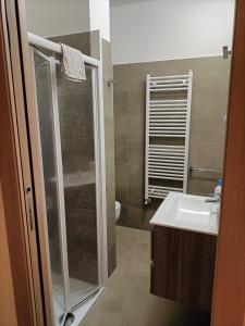 La salle de bains est pourvue d'une douche et d'un lavabo. dans l'établissement Primae Noctis Rooms in Apartments, à Roccascalegna