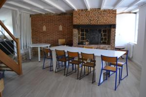a room with a table and chairs and a fireplace at La clef des champs in Doudeville