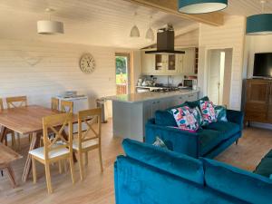 a living room with a blue couch and a table at Stag Lodge School House Farm in Leighton