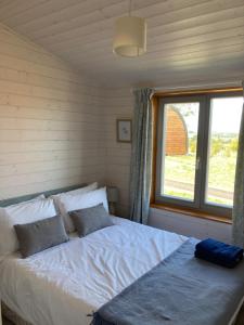 a bedroom with a large bed with a window at Stag Lodge School House Farm in Leighton