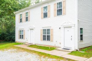 ein weißes Haus mit zwei Fenstern und einer Tür in der Unterkunft Serine Space - Townhome - King Bed - Duke - Long Term Stays in Durham