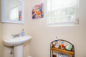 ein Badezimmer mit Waschbecken und Spiegel in der Unterkunft Serine Space - Townhome - King Bed - Duke - Long Term Stays in Durham + 18 Fotos