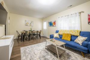 ein Wohnzimmer mit einem blauen Sofa und einem Tisch in der Unterkunft Serine Space - Townhome - King Bed - Duke - Long Term Stays in Durham