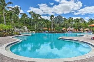 a swimming pool at a resort with palm trees at Lely Resort Condo about 10 Mi to Naples Beach! in Lely Resort