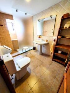 La salle de bains est pourvue de toilettes, d'un lavabo et d'un miroir. dans l'établissement CASA BAUTISTA TURIS, à Turís
