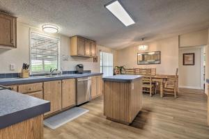 a kitchen with wooden cabinets and a dining room at Family-Friendly San Marcos Home Close to TSU! in San Marcos