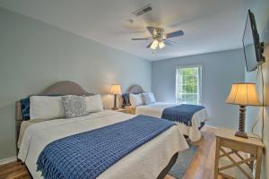 a bedroom with two beds and a ceiling fan at Bright Ozarks Condo with Balcony and Lake Views! in Kimberling City