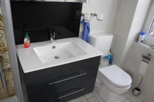 een badkamer met een witte wastafel en een toilet bij Grüntal Residenz I Whg 6 in Grömitz