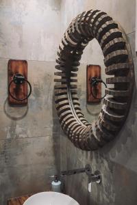 La salle de bains est pourvue d'un grand miroir circulaire sur le mur. dans l'établissement KT Villa, à Troulos