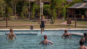 una mujer está parada en una piscina en Pampas del Sur Hotel y Spa de campo en Cañuelas