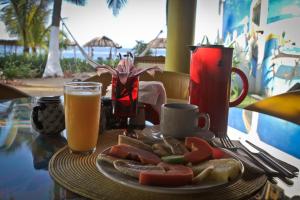 a table with a plate of food and a drink at Hotel Gilda in Coyuca