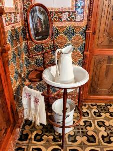 uma casa de banho com uma chaleira e um espelho. em CASA BAUTISTA TURIS em Turís