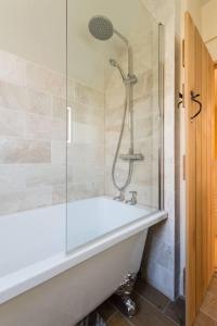 a bathroom with a bath tub and a shower at Lovely Cosy Stone Cottage in Tetbury Cotswolds in Tetbury