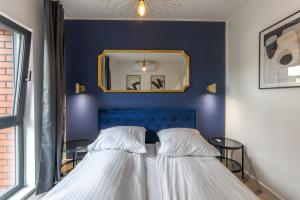 a blue bedroom with a bed and a mirror at Apartament Centrum Gdańska blisko Starego Miasta in Gdańsk