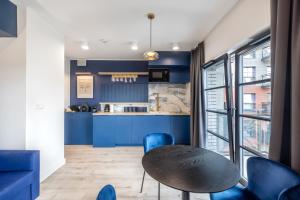 a kitchen with blue walls and a table and chairs at Apartament Centrum Gdańska blisko Starego Miasta in Gdańsk