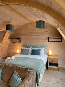 a bedroom with a bed and a couch in a room at Owl Glamping Pod in Leighton