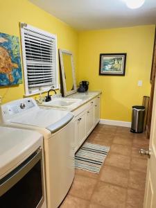 a yellow kitchen with a sink and a mirror at Comfy Beach House on Vero Beach in Vero Beach