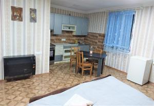 a kitchen with blue cabinets and a table and chairs at Apartment BESO in Kutaisi