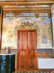 a room with a painting on the wall and a wooden door at CASA BAUTISTA TURIS in Turís