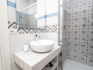 y baño con lavabo blanco y espejo. en Affittacamere Solki, en SantʼAntìoco