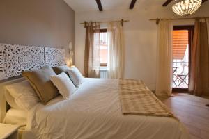 Schlafzimmer mit einem großen weißen Bett und einem Fenster in der Unterkunft Cheerful and cosy home in beautiful Nemi in Nemi