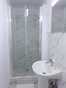 uma casa de banho branca com um chuveiro e um lavatório. em Bucharest Wheel View em Bucareste