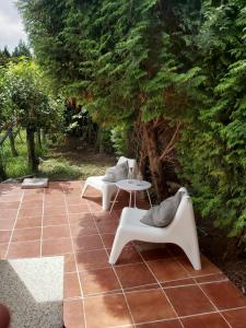 a patio with two chairs and a table and a tree at casa da xusta in Picoña