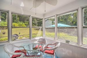 a screened in porch with two chairs and a glass table at Stockbridge Home Walk to Town Beach! in Stockbridge