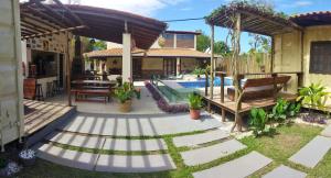un patio trasero con piscina y una casa en Abrolhos Dive Inn en Caravelas