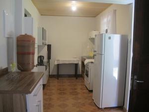 a kitchen with a white refrigerator and a sink at Janela dos Meus Sonhos in Penedo