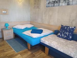 um quarto com 2 camas individuais e uma mesa de cabeceira em Klinkierowa Komnata em Gniezno