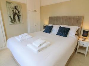 a bedroom with a white bed with towels on it at 148 Fairfield Road in Morecambe