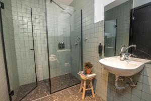 een badkamer met een wastafel en een glazen douche bij Selina Tel Aviv Beach in Tel Aviv