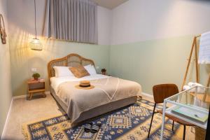 Selina Tel Aviv Beach في تل أبيب: غرفة نوم مع سرير مع قبعة عليه