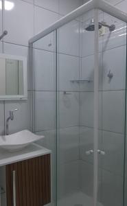 a glass shower in a bathroom with a sink at FlatStudio04 em condomínio residencial na Nova Betânia in Mossoró