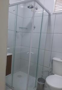 y baño con ducha de cristal y aseo. en FlatStudio04 em condomínio residencial na Nova Betânia, en Mossoró