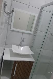 W łazience znajduje się biała umywalka i lustro. w obiekcie FlatStudio04 em condomínio residencial na Nova Betânia w mieście Mossoró