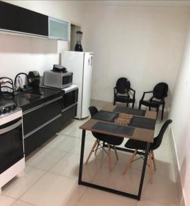 cocina con mesa, sillas y nevera en FlatStudio04 em condomínio residencial na Nova Betânia, en Mossoró