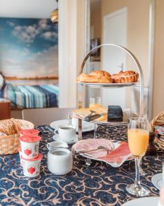 een tafel met brood en zoete deegwaren erop bij Villa De Keyser in Eeklo