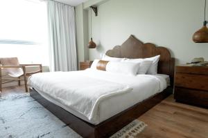 a bedroom with a large bed with a wooden headboard at CODA Williamsburg in Brooklyn +52 photos