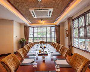 una gran sala de conferencias con una mesa larga y sillas en City Lodge Hotel Pinelands en Ciudad del Cabo