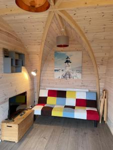 LeightonにあるHedgehog Glamping Pod School House Farmの木製の部屋にベッド1台が備わるベッドルーム1室があります。