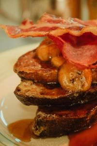 a stack of pancakes with bacon and syrup on a plate at Ben A'an House in Callander