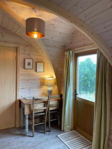 an arched room with a desk in a tiny house at Hedgehog Glamping Pod School House Farm in Leighton