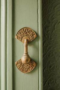 una puerta de bronce en una puerta verde en Ben A'an House, en Callander