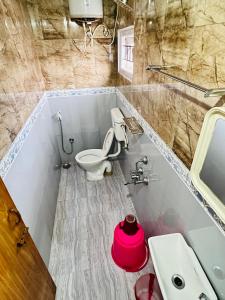 a bathroom with a toilet and a sink at Down House 19 Ooty - TEYT HOLIDAYS in Ooty