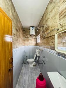 a bathroom with a toilet and a sink at Down House 19 Ooty - TEYT HOLIDAYS in Ooty